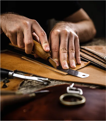 Artisan découpant du cuir avec précision.